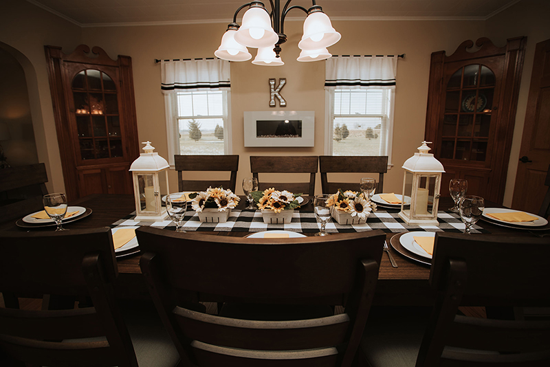 Picture of the dining room at Grandma's House at Cirle K Farm, with the table set and a bright chandelier hanging above the dining room table