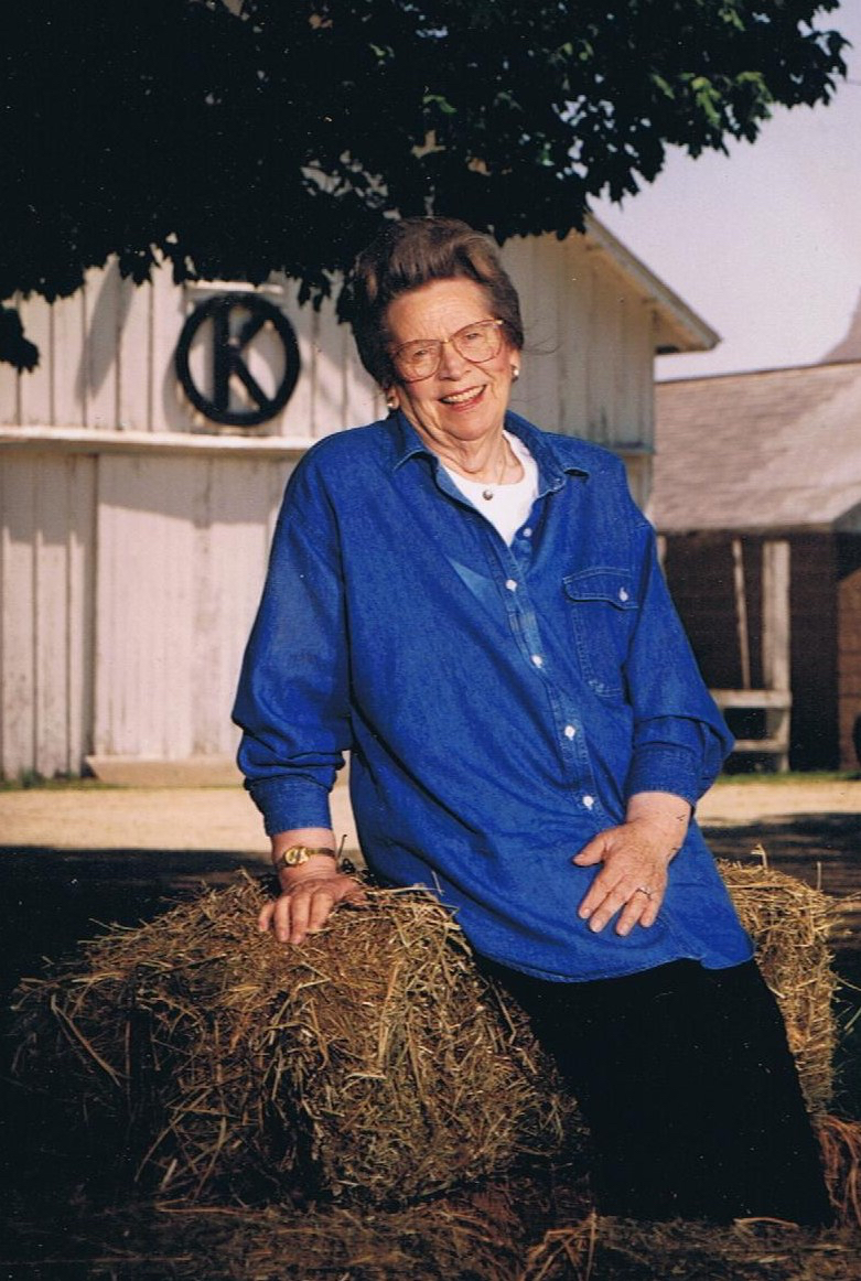 Picture of Grandma on a bale of hay with Circle K in the background.